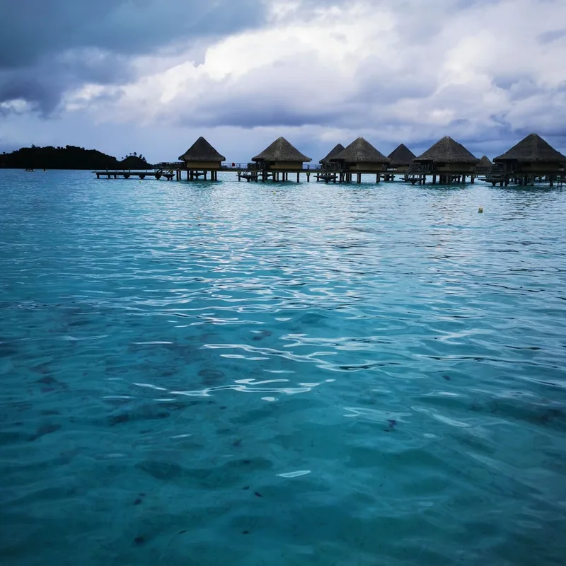 Overwater villas above turquoise sea at a tropical island resort